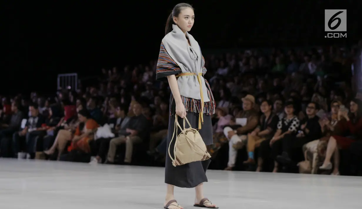 Model membawakan busana karya para perancang yang tergabung dalam Kopikkon pada Indonesia Fashion Week 2018 di JCC, Jakarta, Sabtu (31/3). Kopikkon merupakan bagian dari pengembangan ekonomi kreatif nasional bentukan Bekraf. (Liputan6.com/Faizal Fanani)