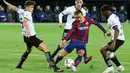 Penyerang Barcelona, Antoine Griezmann, berusaha melewari pemain Valencia pada laga Liga Spanyol di Stadion Mestalla, Minggu (2/5/2021). Barcelona menang dengan skor 2-3. (AFP/Jose Jordan)