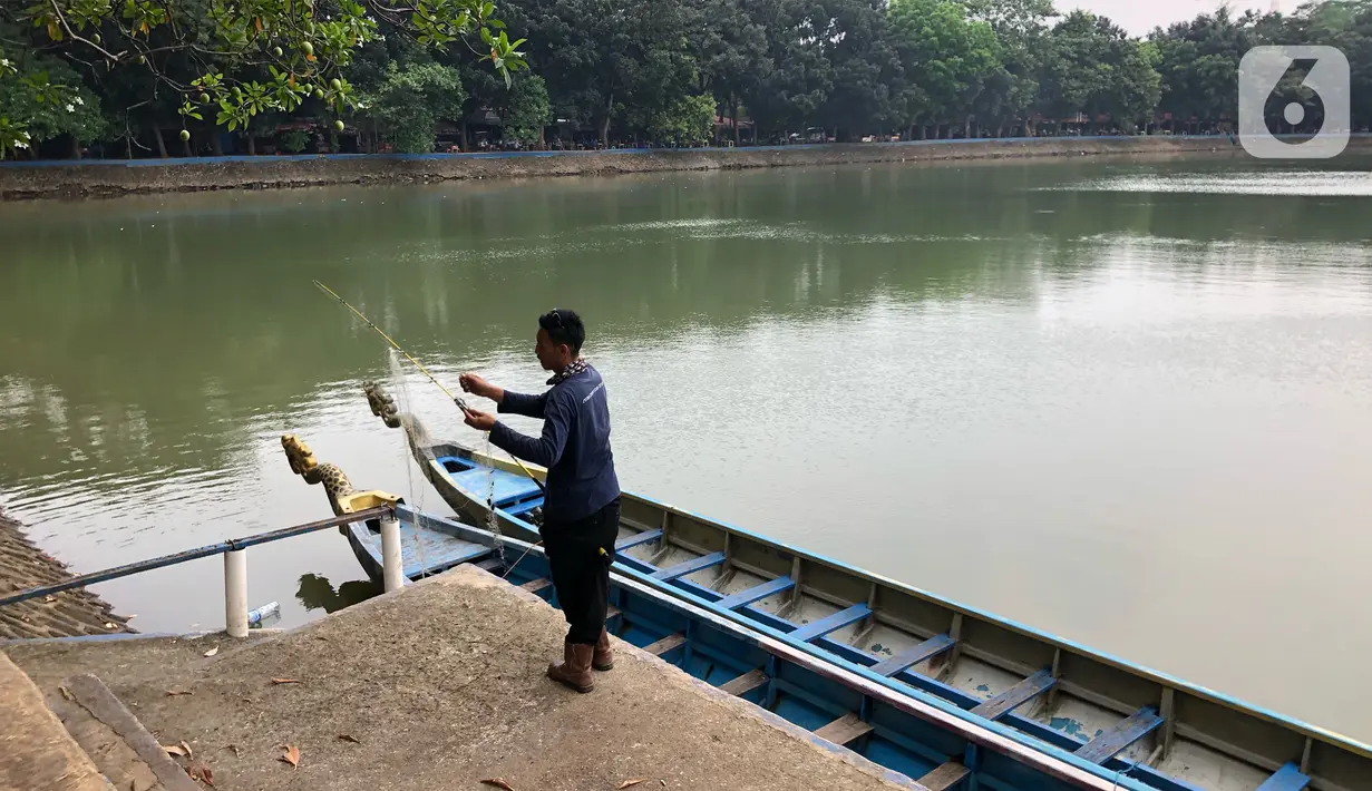 Seorang pria membawa alat pancing saat di Perkampungan Budaya Betawi Setu Babakan, Jakarta, Senin (22/6/2020). Danau buatan seluas 30 hektare tersebut kembali dibuka untuk umum setelah sebelumnya ditutup untuk mencegah penyebaran virus corona COVID-19. (Liputan6.com/Immanuel Antonius)