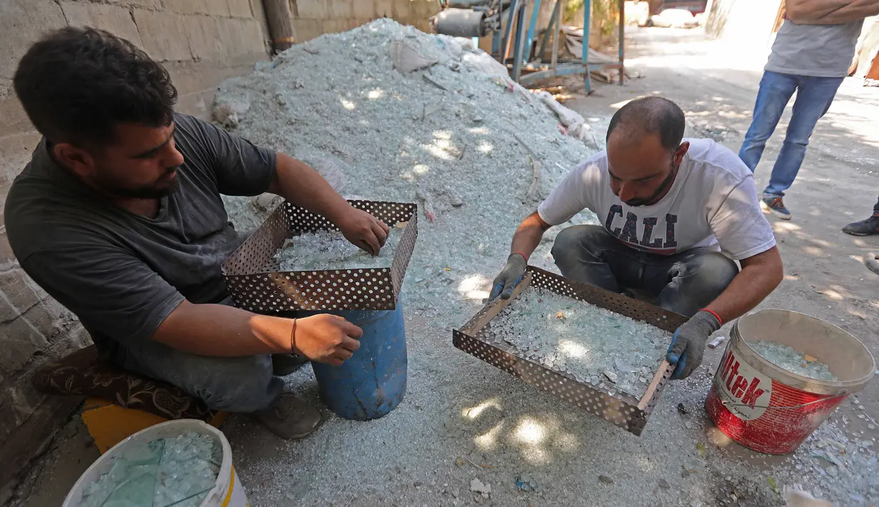 Para pekerja menyaring pecahan kaca di sebuah pabrik kaca di Tripoli, Lebanon, 12 September 2020. Kaca-kaca dari bangunan yang rusak akibat ledakan Beirut didaur ulang oleh warga setempat untuk dijadikan barang pecah belah. (Xinhua/Bilal Jawich)