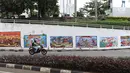 Kendaraan melintasi mural bertema Pemilu 2019 di kawasan Dukuh Atas, Jakarta, Senin (1/4). Mural-mural tersebut dibuat dalam rangka menyukseskan Pemilu yang akan berlangsung pada 17 April 2019 mendatang. (Liputan6.com/Immanuel Antonius)