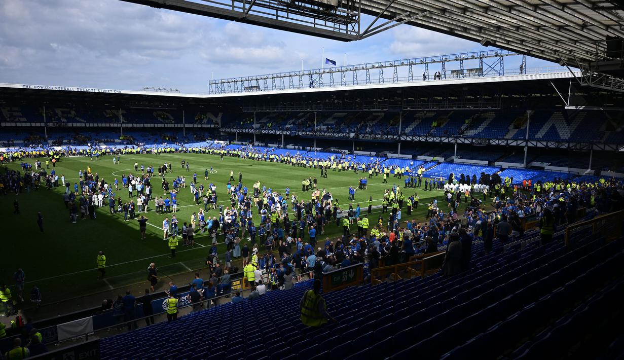 Para penonton memasuki lapangan pertandingan untuk merayakan perpisahan setelah laga lanjutan Liga Inggris 2024/2025 Everton melawan Southampton di Goodison Park, Liverpool, Inggris, Minggu (18/05/2025) waktu setempat. (AFP/Paul Ellis)