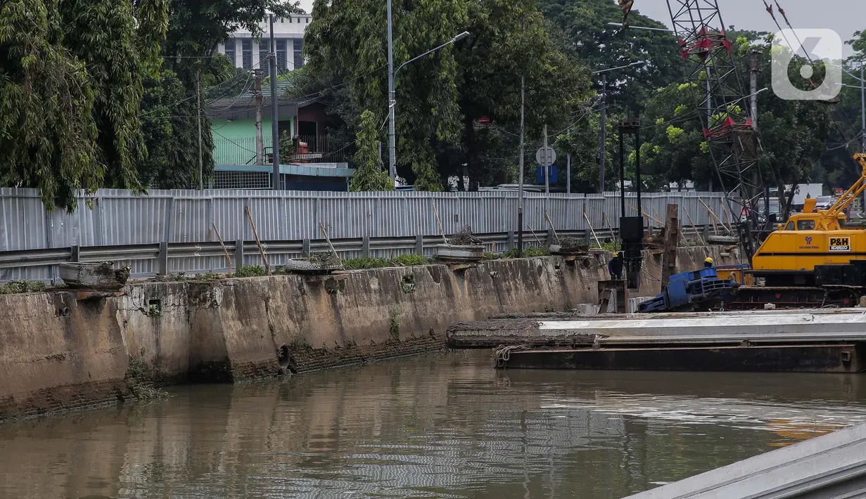 Pekerja menyelesaikan pemasangan dinding turap di kali pasar baru, Jakarta, Rabu (9/3/2022). Dinas Sumber Daya Air DKI Jakarta melakukan pemasangan turap bertujuan untuk mengantisipasi banjir serta tanah ambles di pinggir sungai. (Liputan6.com/Faizal Fanani)