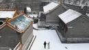 Wisatawan berdiri saat menikmati suasana salju di lingkungan Tembok Besar China di utara Beijing (6/1/2020). Awal tahun 2020, musim dingin turun menyelimuti bagian utara Beijing yang mengakibatkan lokasi wisata yang menjadi salah satu keajaiban dunia tertutup salju. (AFP/Greg Baker)