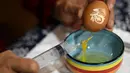 Perajin Zhang Xiaohe mengeluarkan isi telur di sebuah lokakarya warisan budaya takbenda di Shijiangzhuang, China, pada 17 April 2020. Ukiran telur sering disebut "seni yang paling rapuh", karena membutuhkan ketelitian dan perhatian tinggi sebelum, selama dan setelah pembuatannya. (Xinhua/Chen Qibao)