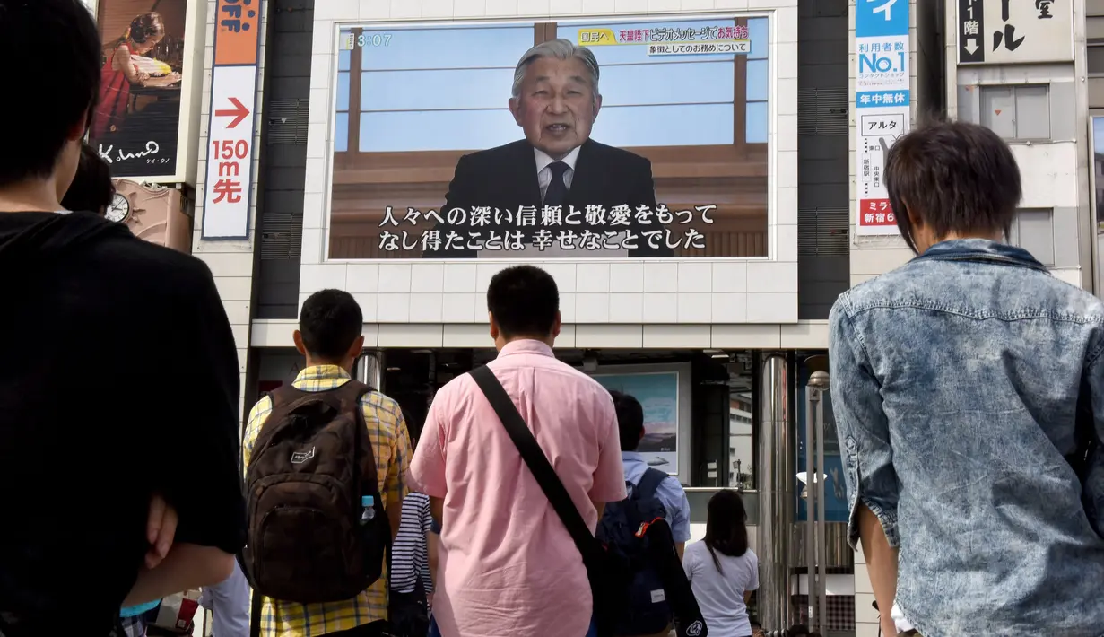 Warga menyaksikan video pidato Kaisar Akihito di Tokyo, Jepang, (8/8). Kaisar mengungkapkan keinginannya untuk turun tahta karena faktor kesehatan dan kekhawatiran dirinya tidak mampu melaksanakan tugas Kekaisaran secara penuh. (AFP PHOTO/Toru Yamanaka)
