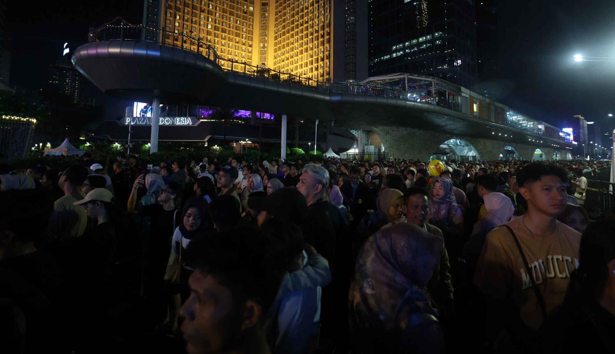 Puluhan ribu warga mulai berdatangan sejak Rabu (31/12/2025) sore hari untuk menanti momen pergantian tahun. Tampak dalam foto, suasana kepadatan warga yang akan menikmati malam pergantian tahun di kawasan Bundaran Hotel Indonesia, Jakarta, Rabu (31/12/2025). (Kapanlagi.com/Budy Santoso)