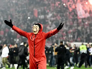 Suporter Olympiakos turun ke lapangan merayakan kemenangan atas AC Milan pada laga Europa di Stadion Georgios Karaiskakis, Athena, Kamis (13/12). Olympiakos menang 3-1 atas AC Milan. (AFP/Aris Messinis)