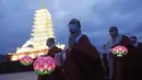 Para biksu yang mengenakan masker berjalan di sekitar menara lentera berbentuk pagoda saat merayakan ulang tahun Buddha di Gwanghwamun Plaza, Seoul, Korea Selatan, Kamis (30/4/2020). Ulang tahun Buddha kali ini dirayakan di tengah pandemi virus corona COVID-19. (AP Photo/Ahn Young-joon)