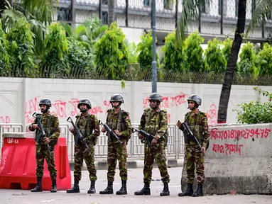 Personel militer Bangladesh berjaga selama jam malam menyusul bentrokan antara polisi dan aktivis Gerakan Mahasiswa Anti-Diskriminasi di tengah protes anti-pemerintah di daerah Shahbag, Dhaka, Senin (5/8/2024). (Munir UZ ZAMAN / AFP)