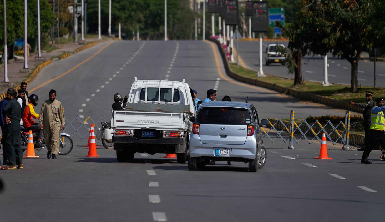 Sebagai informasi, pihak Iran dikabarkan belum memberikan konfirmasi resmi terkait kehadiran mereka dalam perundingan putaran kedua dengan Amerika Serikat di Islamabad, Pakistan. Tampak dalam foto, petugas polisi mengalihkan kendaraan di pos pemeriksaan yang dibarikade menjelang putaran kedua negosiasi antara kedua negosiasi antara Amerika Serikat dan Iran, di Islamabad, Pakistan, Selasa 21 April 2026. (AP Photo/Anjum Naveed)