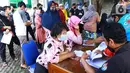Warga antre menerima Bantuan Sosial Tunai (BST) di Kelurahan Pondok Benda, Kecamatan Pamulang, Tangerang Selatan, Minggu (10/01/2021). Sebanyak 92.737 kepala keluarga tercatat sebagai penerima BST di wilayah Tangerang Selatan senilai Rp300 ribu. (Liputan6.com/Fery Pradolo)