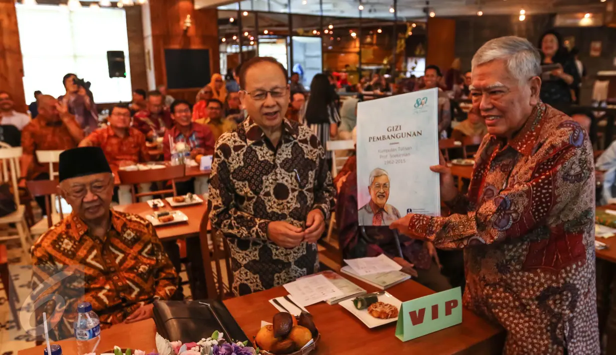 Prof Soekirman secara simbolis memberikan buku kepada Gus Solahudin Wahid pada peluncuran buku Gizi Pembangunan di Jakarta, Sabtu (01/10). Buku tersebut berisi kumpulan tuisan Soekirman dari IPB selama tahun 1962-2015. (Liputan6.com/Fery Pradolo)