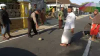 Polisi menunjukkan batu yang dipakai pelaku untuk memukul kepala nenek-nenek yang hendak pergi ke musala, Kamis (13/9 - 2018). (Solopos.com/Istimewa/Polres Ponorogo)