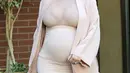 Kim tetap tampil modis dan seksi selama hamil, ia memakai mantel warna senada dengan baju ketat yang dipakainya. (via dailymail.co.uk)