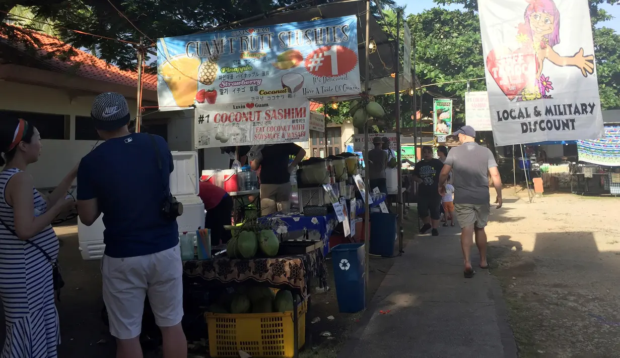 Orang-orang berjalan melewati pasar Chamorro Village di Hagatna, Guam, Rabu (9/8). Meskipun suasana ketegangan di kawasan itu meningkat terkait ancaman bom nuklir Korea Utara, warga Guam tetap beraktivitas seperti biasa. (AP Photo/Grace Garces Bordallo)