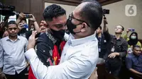 Terdakwa kasus penganiayaan kepada Cristalino David Ozora, Mario Dandy Satriyo memeluk Rafael Alun Trisambodo yang menjadi terdakwa pada kasus dugaan gratifikasi dan tindak pidana pencucian uang (TPPU) sesaat sebelum mengikuti sidang lanjutan di Pengadilan Tipikor, Jakarta, Senin (6/11/2023). (Liputan6.com/Faizal Fanani)