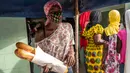 Ndyeye Fatou, putri Bara Tambedou, mengenakan masker saat membeli roti pada bulan suci Ramadan, di Dakar, Senegal, 25 April 2020. Tahun ini, banyak keluarga menjalankan Ramadan di rumah dengan larangan pertemuan publik dan jam malam untuk menekan penyebaran Covid-19. (AP/Sylvain Cherkaoui)