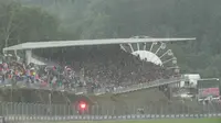 Foto ini menunjukkan para penonton di tribun saat start balapan ditunda akibat keterbatasan jarak pandang selama Grand Prix Formula Satu Belgia di sirkuit Spa-Francorchamps, Spa, pada 27 Juli 2025. (Dimitar DILKOFF/AFP)