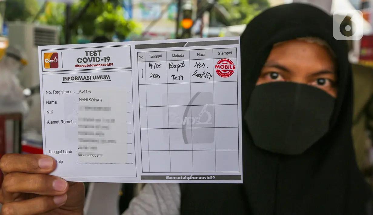 Warga menunjukkan kartu test Covid-19 usai rapid test massal di Kantor Kelurahan Pondok Betung, Tangerang Selatan, Kamis (14/5/2020). Rapid test yang digelar Badan Intelijen Negara (BIN) untuk memastikan positif atau tidaknya warga terjangkit Covid-19. (Liputan6.com/Fery Pradolo)