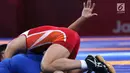 Pegulat putra Indonesia, Muhammad Aliansyah saat bertarung melawan pegulat Korea Utara Kim Myong Chol pada kelas putra 67 Kg di arena gulat JCC Senayan, Selasa (21/8). (Liputan6.com/Fery Pradolo)