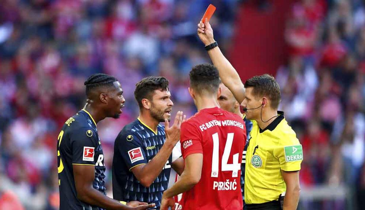 Wasit memberikan kartu merah kepada pemain Koln, Kinglsey Ehizibue, pada laga Bundesliga di Allianz Arena, Sabtu (21/9/2019). Bayern Munchen menang 4-0 atas Koln. (AP/Matthias Schrader)