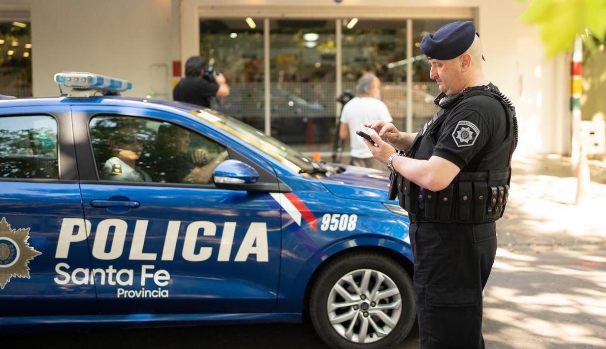 Polisi berkumpul di luar supermarket Unico, jaringan toko kelontong milik mertua pemain sepak bola Lionel Messi, setelah ditembak di Rosario, Argentina, 2 Maret 2023. Wali Kota Rosario Pablo Javkin menyalahkan pasukan keamanan karena gagal memberantas kejahatan terorganisasi secara efektif, yang dalam beberapa tahun terakhir telah berkembang di kota pelabuhan penting, di mana puluhan kapal setiap hari memuat ribuan ton biji-bijian. (AP Photo/Sebastian Lopez Brach)