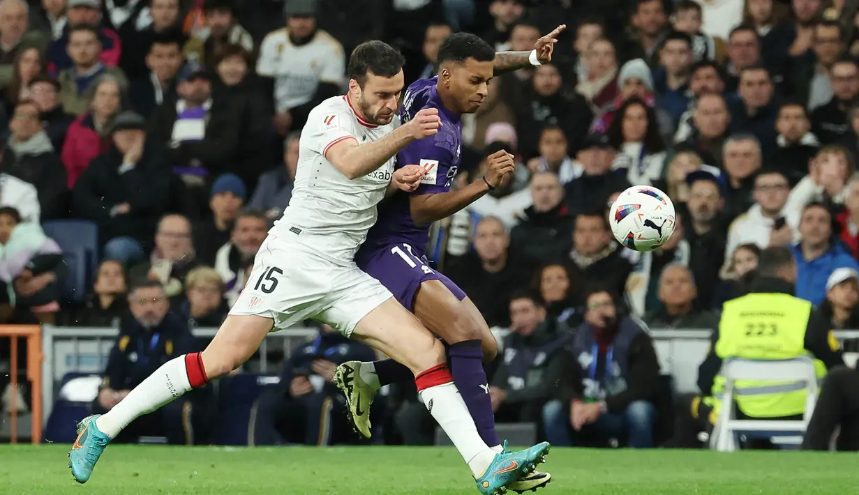 Pemain Real Madrid, Rodrygo, berusaha melewati pemain Athletic Bilbao, Inigo Lekue, pada laga Liga Spanyol di Stadion Santiago Bernabeu, Minggu (31/3/2024). (AFP/Pierre-Philippe Marcou)