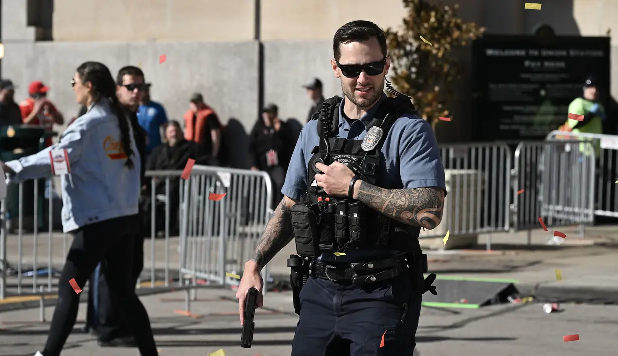 Personel kepolisian memberikan respon ketika terjadi tragedi penembakan di parade kemenangan Kansas City Chiefs setelah memenangkan Super Bowl LVIII di Kansas City, Missouri, Amerika Serikat, Rabu (14/02/2024) waktu setempat. Sebanyak 21 orang terluka dan satu orang meninggal dunia akibat teror tersebut. (AFP/Andrew Caballero-Reynolds)