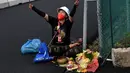 Seorang pawang hujan melakukan ritual saat sesi latihan bebas MotoGP Indonesia di Sirkuit Mandalika, Mandalika, Lombok Tengah, Nusa Tenggara Barat, Jumat (18/3/2022). (AFP/Bay Ismoyo)