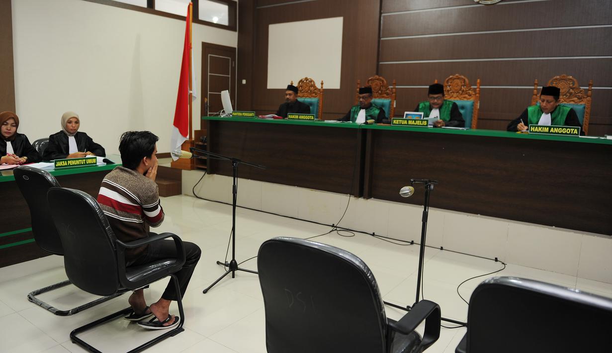 Salah seorang terdakwa pasangan sejenis (gay) di Aceh saat menghadiri persidangannya di pengadilan syariah di Banda Aceh (17/5). Majelis hakim Mahkamah Syar'iyah Banda Aceh memvonis terdakwa dengan 85 kali cambuk. (AFP/Chaideer Mahyuddin)
