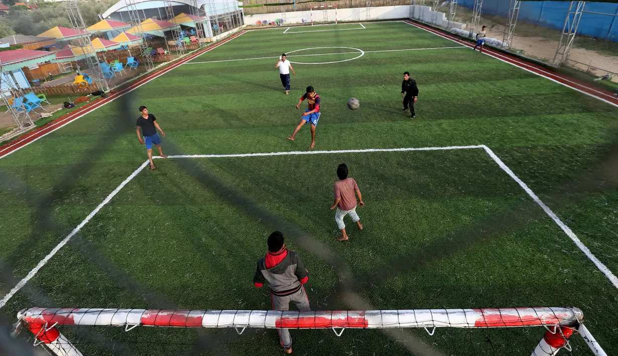 Warga Palestina bermain sepak bola di lapangan futsal, Khan Younis, Jalur Gaza, (4/6). Meski negara tersebut mengalami berbagai konflik tetapi mereka tetap menghibur diri dengan bermain bola bersama. (REUTERS / Ibraheem Abu Mustafa)