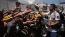 Warga Palestina menerima sumbangan makanan di pusat distribusi di Khan Younis, Jalur Gaza, Rabu 27 Mei 2026. (AP Photo/Abdel Kareem Hana)