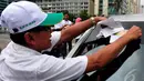 Seorang aktivis memasang striker anti-korupsi ke salah satu mobil yang melintas di Bundaran HI, Jakarta, Selasa (12/9/2014). (Liputan6.com/Johan Tallo)