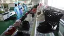 Sepatu-sepatu dipajang saat para pekerja yang memakai masker bekerja di Pabrik Sepatu Kulit Wonsan, tempat mereka memproduksi sepatu kulit buatan tangan di Wonsan, Provinsi Kangwon, Korea Utara pada 28 Oktober 2020. (AP Photo/Jon Chol Jin)
