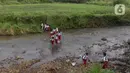 Sejumlah pelajar Sekolah Dasar (SD) menyeberangi sungai Cihideung untuk menuju sekolah mereka di Kampung Sempur, Kabupatan Bogor, Jawa Barat, Selasa (15/4/2025). (Liputan6.com/Herman Zakharia)