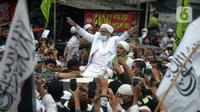 Rizieq Shihab menyapa massa pendukungnya saat tiba di kediamannya di Jalan Petamburan, Jakarta, Selasa (10/11/2020). Rizieq Shihab tiba di kediamannya usai pulang dari Arab Saudi. (merdeka.com/Imam Buhori)