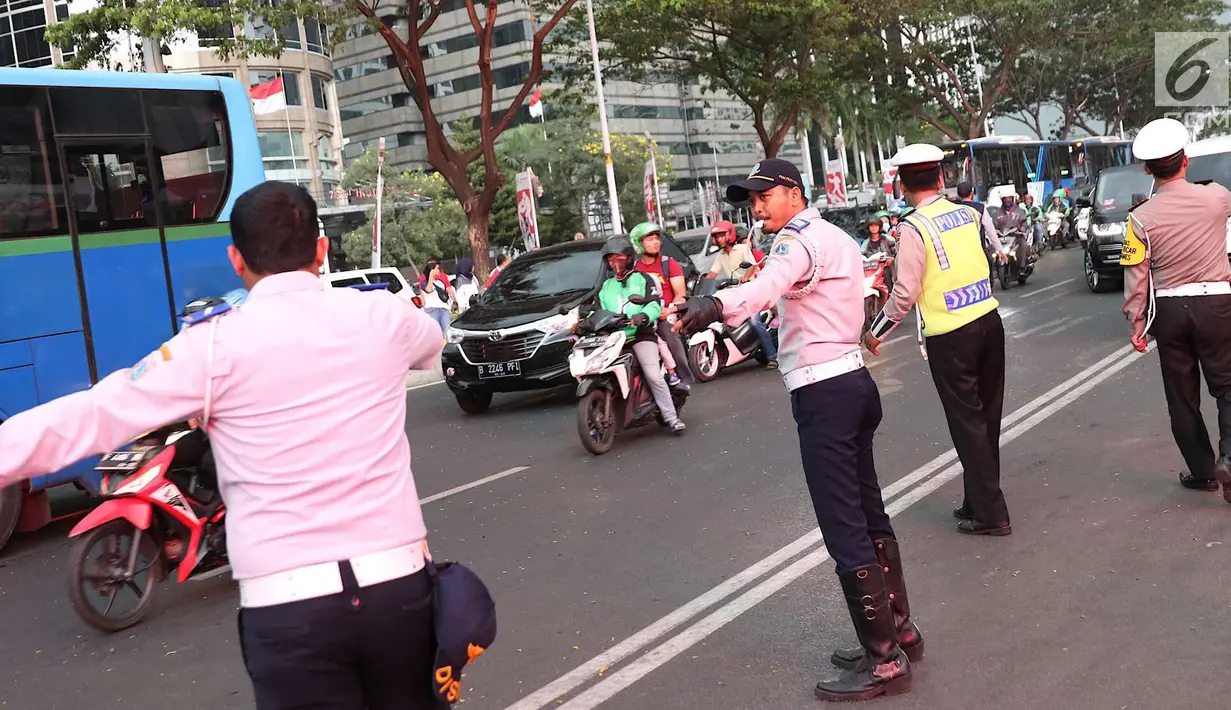 Polisi dan Dishub mengatur lalu lintas di Senayan, Jakarta, Minggu (2/9). Untuk meminimalisasi kemacetan jelang penutupan Asian Games 2018, rekayasa lalu lintas dilakukan di sejumlah ruas jalan dari dan menuji Senayan. (Liputan6.com/Immanuel Antonius)