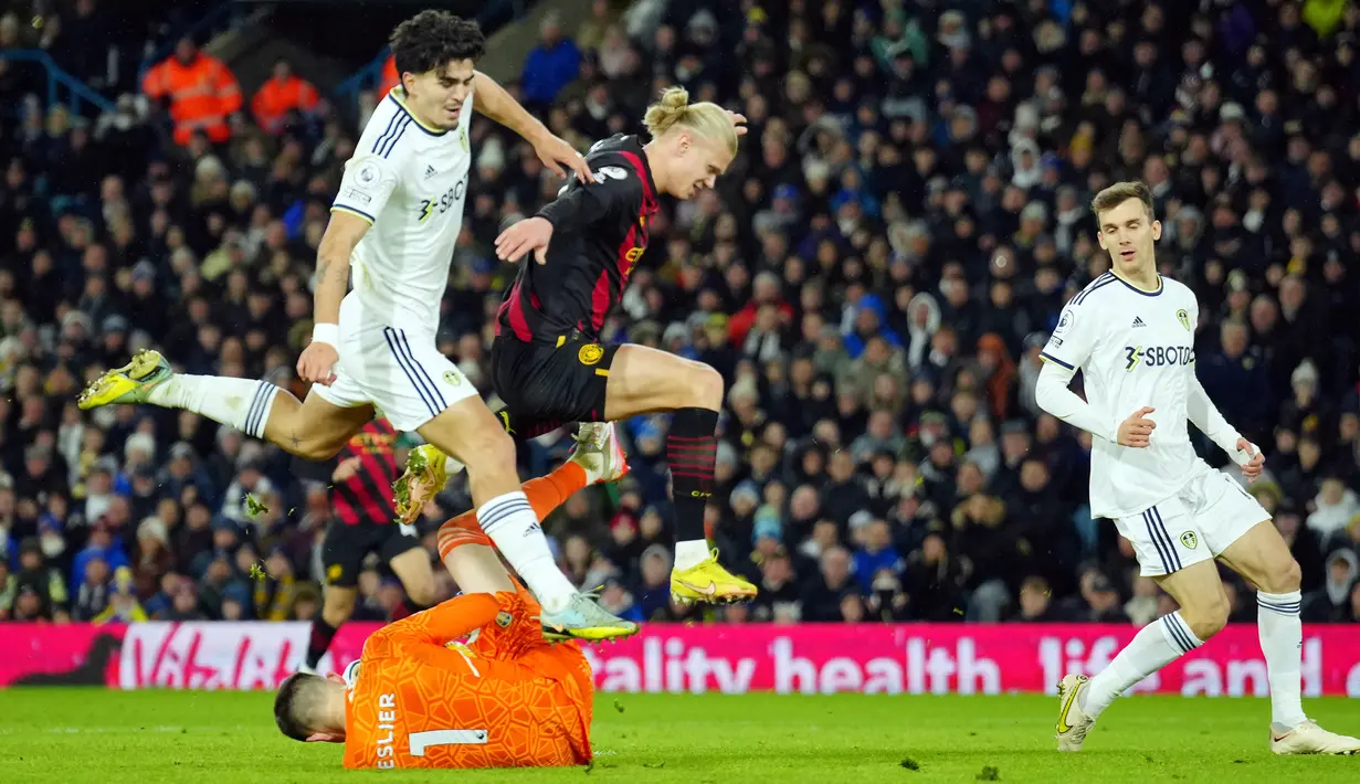 Pemain Leeds United Pascal Struijk (kiri) berebut bola dengan pemain Manchester City Erling Haaland saat kiper Leeds United Illan Meslier melakukan penyelamatan pada pertandingan sepak bola Liga Inggris di Stadion Elland Road, Leeds, Inggris, 28 Desember 2022. Manchester City mengalahkan Leeds United dengan skor 3-1. (AP Photo/Jon Super)