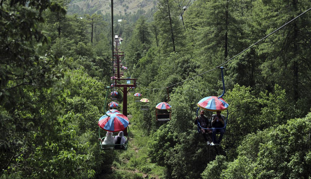 <p>Wisatawan menikmati naik kursi gantung di kota resor bukit Murree, selama hari pertama Idul Fitri di dekat Islamabad, Pakistan, Selasa, 3 Mei 2022. (AP Photo/Rahmat Gul)</p>