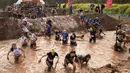 Sejumlah peserta tercebur di kolam lumpur saat memulai perlombaan Mud Day di Tel Aviv, Israel (16/3). Sekitar 5.000 orang ikut berpartisipasi dalam lomba Hari Lumpur di Tel Aviv ini. (AFP Photo/Jack Guez)