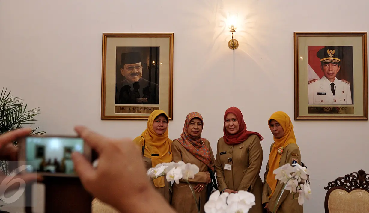 Tampak para Pegawai Negeri Sipil (PNS) berfoto diruangan Balai Kota, Jakarta, Rabu (22/7/2015).  Hari ini adalah hari pertama PNS masuk kerja setelah Libur Panjang Hari Idul Fitri 1436H. (Liputan6.com/JohanTallo)