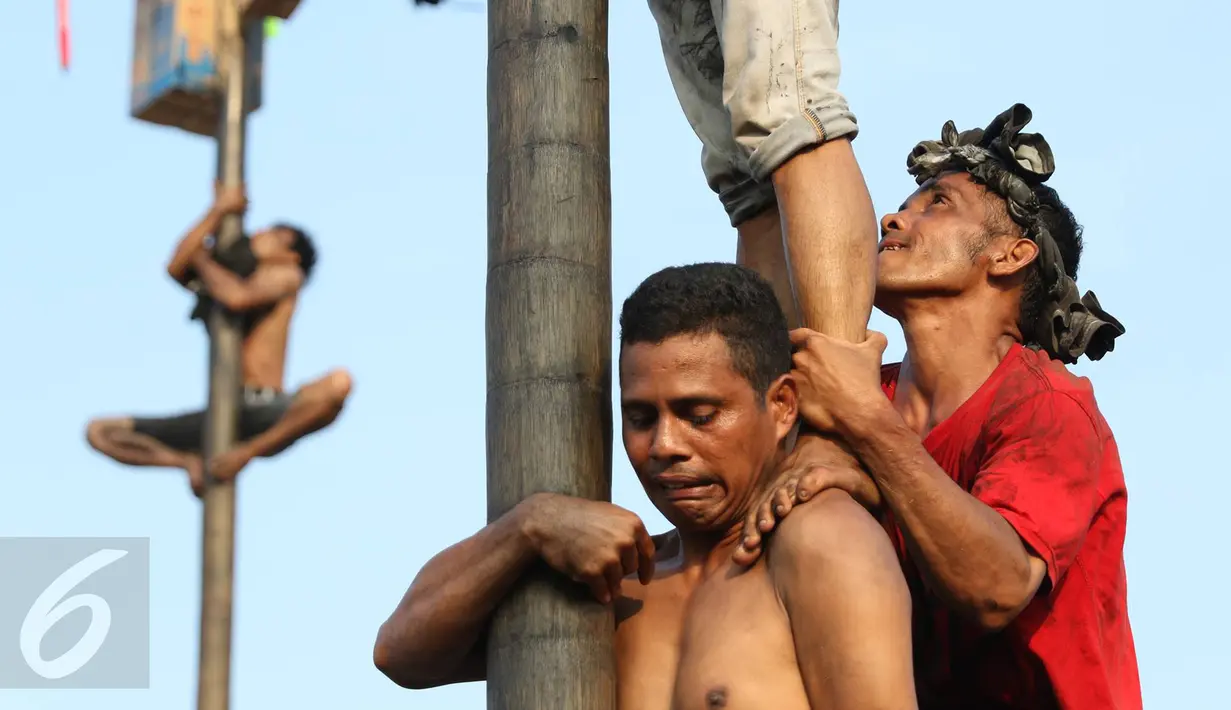 Peserta mengikuti lomba panjat pinang di Taman Impian Jaya Ancol, Jakarta, Rabu (17/8). Sebanyak 171 batang pohon pinang disiapkan panitia dalam rangka memeriahkan Hari Kemerdekaan RI yang ke-71. (Liputan6.com/Immanuel Antonius)