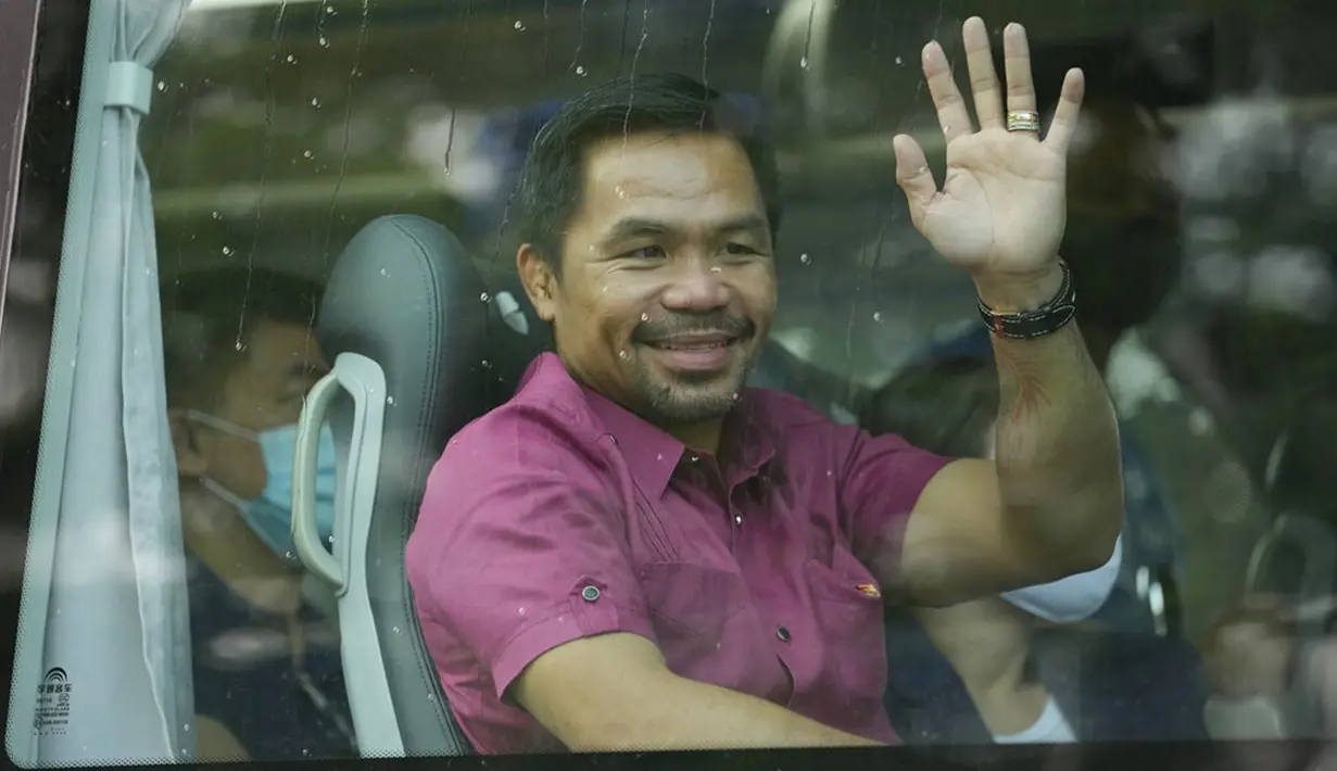 Pensiunan bintang tinju dan senator Filipina Manny Pacquiao melambai dari kendaraannya sebelum mengajukan sertifikat pencalonannya untuk pemilihan presiden tahun depan di Komisi Pemilihan Umum, Manila, Filipina, Jumat (1/10/2021). (AP Photo/Aaron Favila)