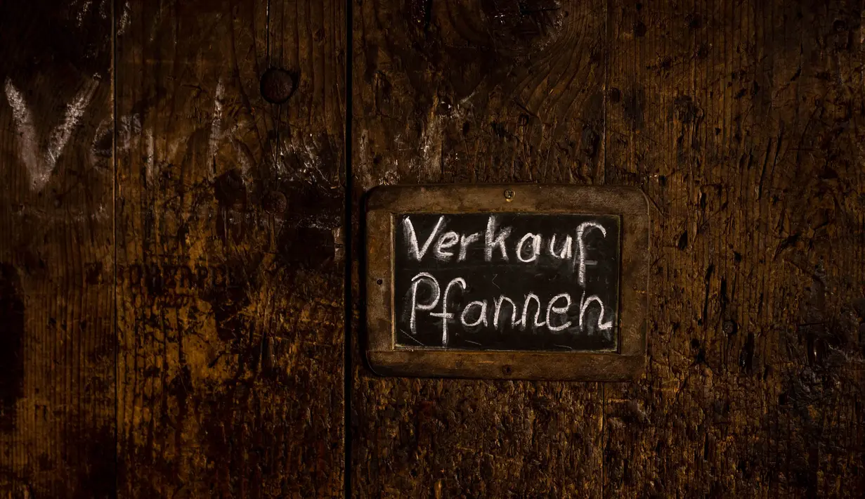 Tulisan tangan penanda 'penjualan wajan besi' dipasang di pintu di tempat penempaan palu milik pandai besi Andreas Rohrmoser, di Bad Oberdorf, Jerman, Senin, 18 September 2023. (AP Photo/Matthias Schrader)