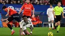 Keunggulan 1-0 untuk tuan rumah bertahan hingga waktu turun minum. Tampak dalam foto, penyerang Real Madrid asal Brasil, Vinicius Junior terjatuh saat berebut bola dengan bek Osasuna asal Spanyol, Alejandro Catena (kiri) selama pertandingan pekan ke-25 La Liga 2025/2026 di Stadion El Sadar, Pamplona pada Sabtu 21 Februari 2026 waktu setempat atau Minggu (22/2/2026) dini hari WIB. (ANDER GILLENEA/AFP)