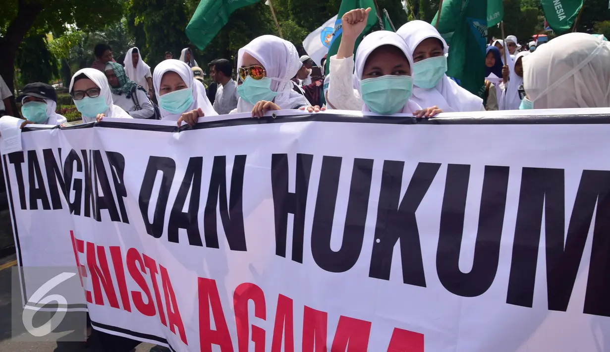 Sejumlah demonstran membawa spanduk saat aksi menuntut Ahok agar segera diadili di Semarang, Jumat (4/11). Gubernur DKI diduga telah melakukan penistaan agama di Kepulauan Seribu. (Liputan6.com/Gholib)