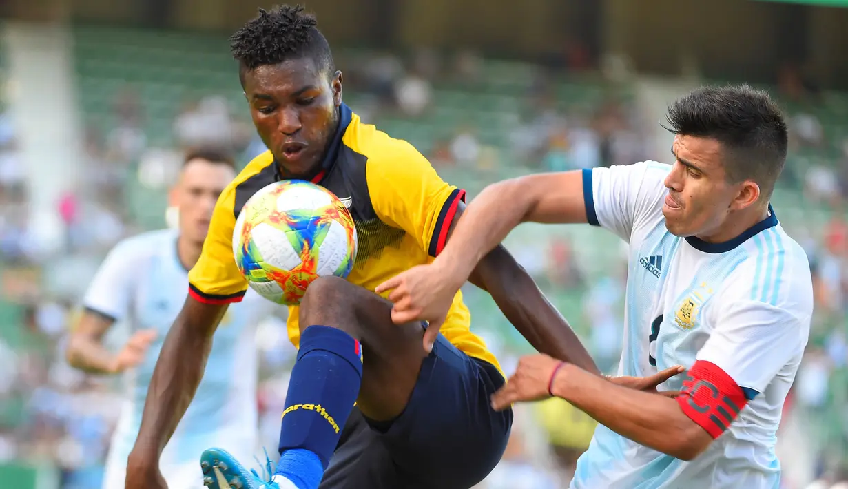 Gelandang Ekuador, Jose Cifuentes, mengamankan bola dari gelandang Argentina, Marcos Acuna, pada laga persahabatan di Stadion Martinez Valero, Elche, Minggu (13/10). Ekuador kalah 1-6 dari Argentina. (AFP/Jose Jordan)