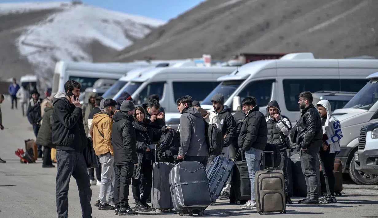 Pergerakan warga ini terjadi di tengah meningkatnya serangan gabungan Amerika Serikat dan Israel terhadap Iran. Tampak dalam foto, warga negara Iran menunggu bus di Turki setelah melewati perbatasan Kapikoy/Razi di Provinsi Van, Turki timur laut, pada Selasa 3 Maret 2026, sehari setelah kedua negara tersebut secara bersama-sama menangguhkan penyeberangan harian di perbatasan mereka karena serangan Israel-Amerika Serikat yang terus menghantam wilayah Republik Islam tersebut. (Ali IHSAN OZTURK/AFP)