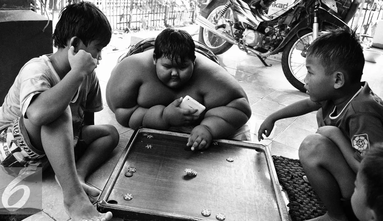 Setelah mandi, Ariya bermain karambol bersama Amir dan Kokok, begitulah panggilan kepada teman dekatnya. (Liputan6.com/Gempur M Surya)